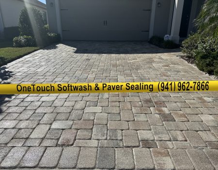 Image of a freshly cleaned pavers with caution tape displaying One Touch Softwash's business phone number on yellow tape.